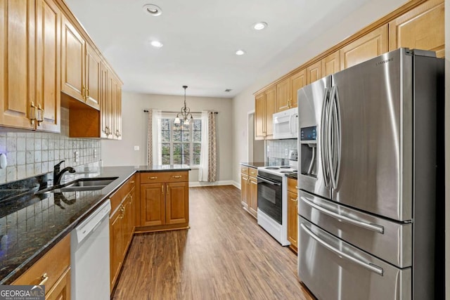 4838 Netherlands Pl, Flowery Branch, GA 30542 - kitchen featuring white appliances, wood finished floors, recessed lighting, a peninsula, and tasteful backsplash