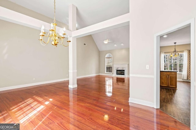 4838 Netherlands Pl, Flowery Branch, GA 30542 - unfurnished living room featuring a chandelier, wood finished floors, healthy amount of natural light, high vaulted ceiling, and a high end fireplace