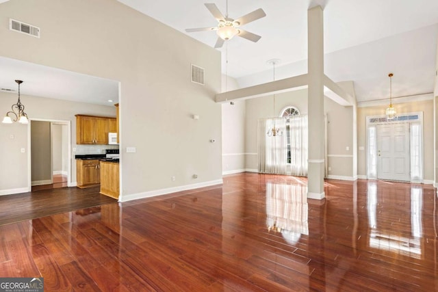 4838 Netherlands Pl, Flowery Branch, GA 30542 - unfurnished living room featuring plenty of natural light, ceiling fan, dark wood-style flooring, a chandelier, and high vaulted ceiling