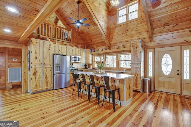 kitchen with visible vents, wood ceiling, light wood-type flooring, beam ceiling, and appliances with stainless steel finishes