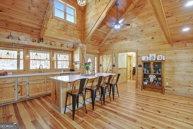 kitchen featuring wood ceiling, light wood finished floors, and a sink