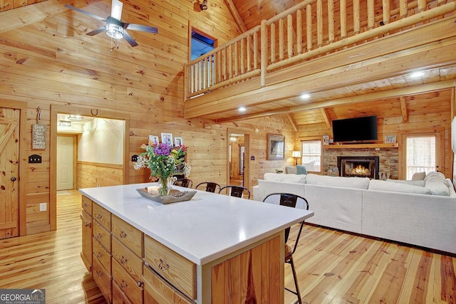 kitchen with wooden walls, a kitchen breakfast bar, and ceiling fan