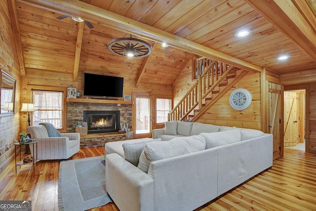 living area featuring wooden ceiling, wooden walls, and beamed ceiling