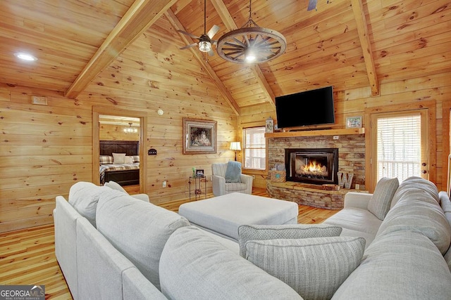 living room with wood ceiling, a healthy amount of sunlight, and a ceiling fan