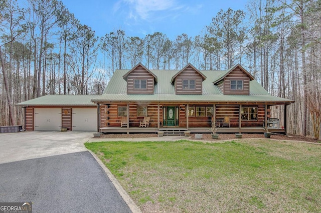 log-style house with aphalt driveway, a porch, a front yard, metal roof, and an attached garage