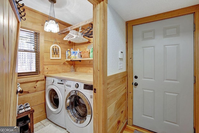 washroom featuring wooden walls, independent washer and dryer, laundry area, and an inviting chandelier