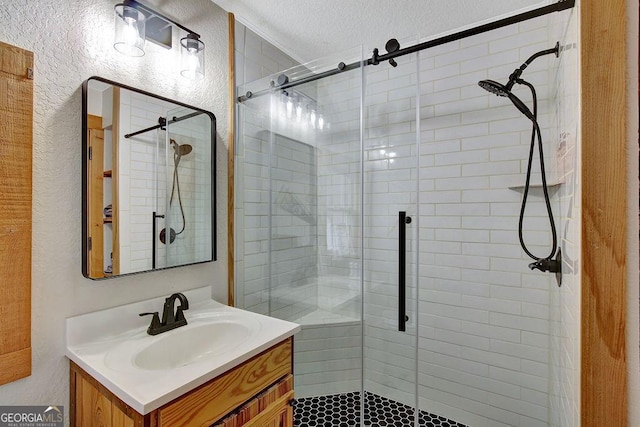 bathroom featuring vanity, a textured wall, a stall shower, and a textured ceiling