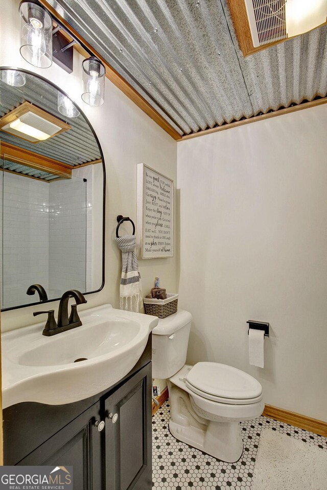 bathroom with visible vents, baseboards, toilet, tile patterned floors, and vanity