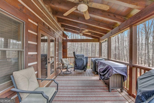 sunroom / solarium featuring lofted ceiling with beams, wooden ceiling, and ceiling fan