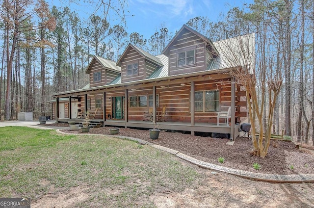 log home featuring metal roof, a porch, and a front yard