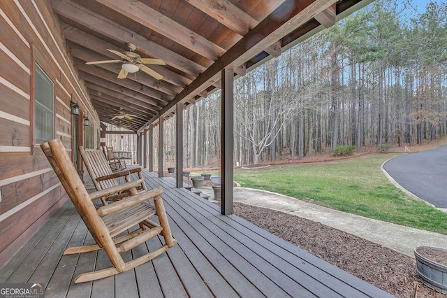 deck with a lawn and ceiling fan