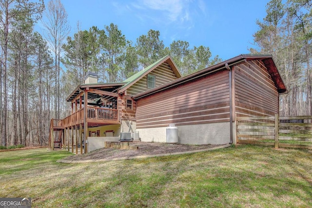 view of home's exterior with a lawn, a deck, stairs, cooling unit, and a chimney