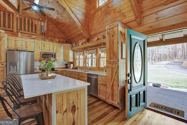 kitchen with light wood-type flooring, light countertops, wooden ceiling, appliances with stainless steel finishes, and a sink