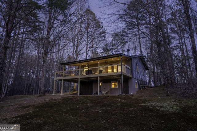 back of property with a deck and a ceiling fan