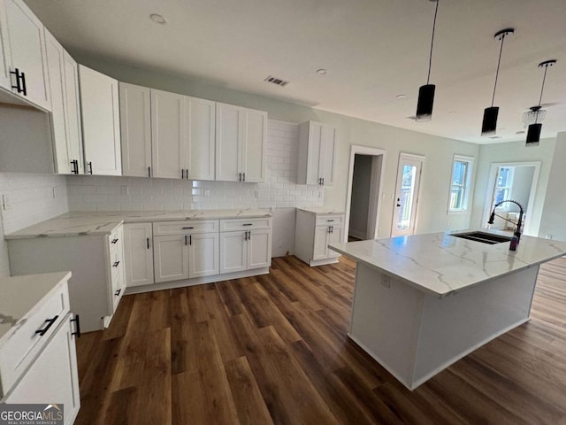 1510 Olympian Way SW, Atlanta, GA 30310 - kitchen with dark wood-style floors, light stone counters, tasteful backsplash, and white cabinets