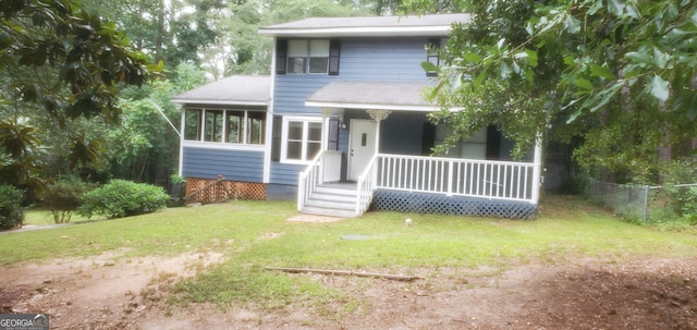 view of front of property featuring a sunroom, covered porch, a front yard, and fence