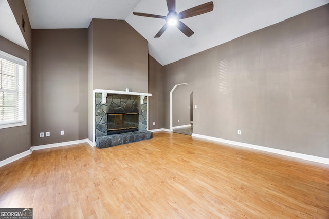 unfurnished living room featuring light wood-type flooring, baseboards, a fireplace, high vaulted ceiling, and ceiling fan