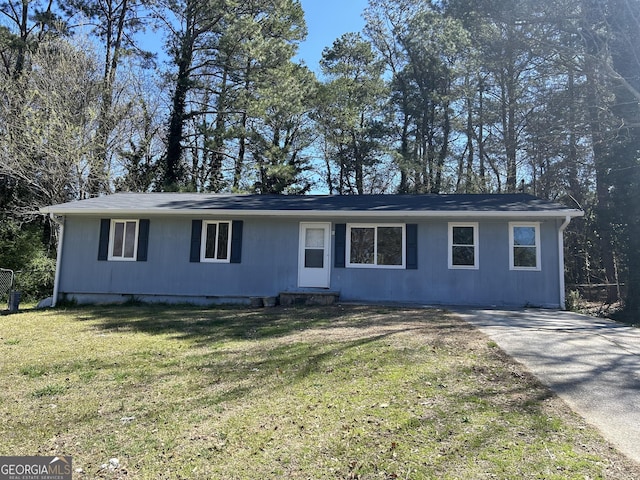 ranch-style house featuring entry steps, concrete driveway, and a front yard