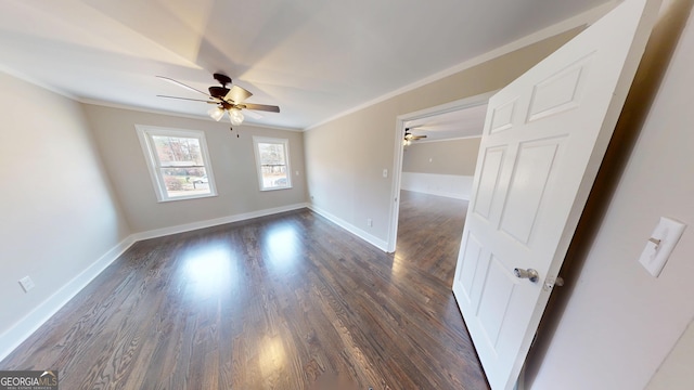 empty room featuring crown molding, a ceiling fan, dark wood-type flooring, and baseboards