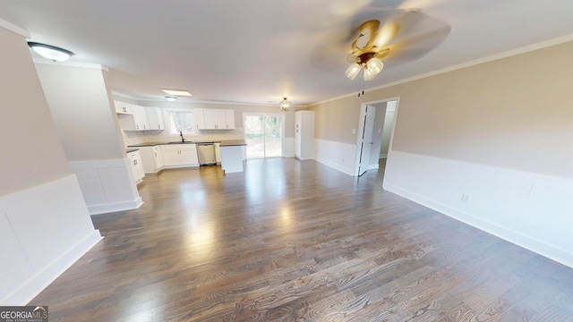 unfurnished living room with a sink, dark wood finished floors, ceiling fan, and crown molding