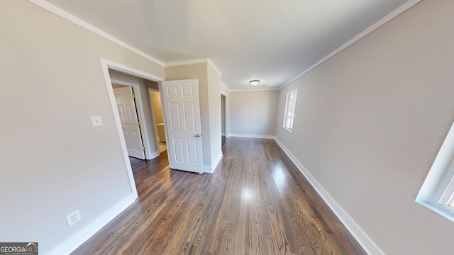 empty room featuring crown molding, baseboards, and dark wood-style flooring