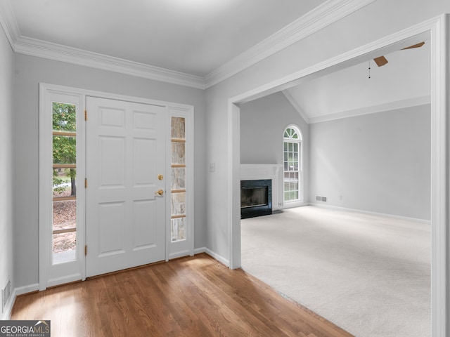 1300 Lakehaven Pkwy, Mcdonough, GA 30253 - foyer entrance featuring ornamental molding, a premium fireplace, vaulted ceiling, wood finished floors, and ceiling fan