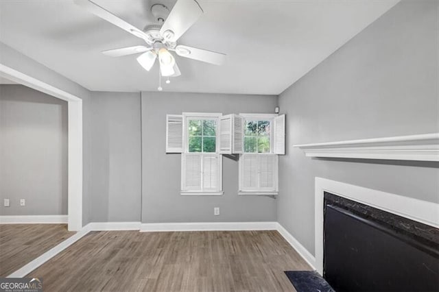 117 Lablanc Way NW, Atlanta, GA 30327 - unfurnished living room featuring a fireplace with flush hearth, baseboards, a ceiling fan, and wood finished floors