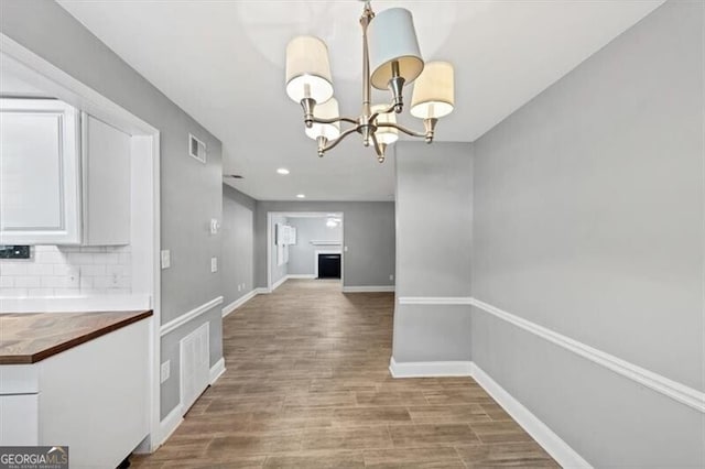 117 Lablanc Way NW, Atlanta, GA 30327 - unfurnished dining area with visible vents, wood finished floors, recessed lighting, an inviting chandelier, and baseboards