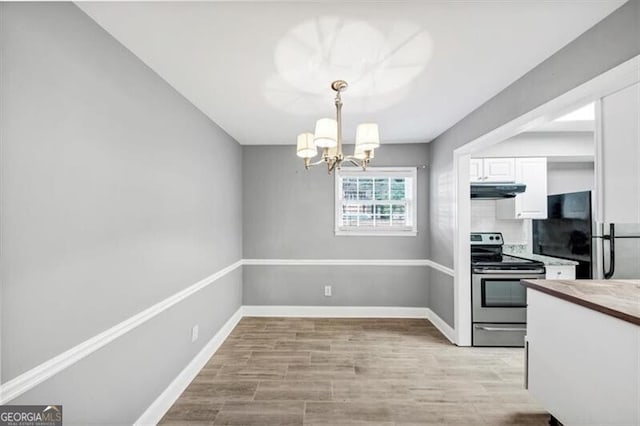 117 Lablanc Way NW, Atlanta, GA 30327 - kitchen with baseboards, under cabinet range hood, stainless steel range with electric stovetop, a notable chandelier, and white cabinetry