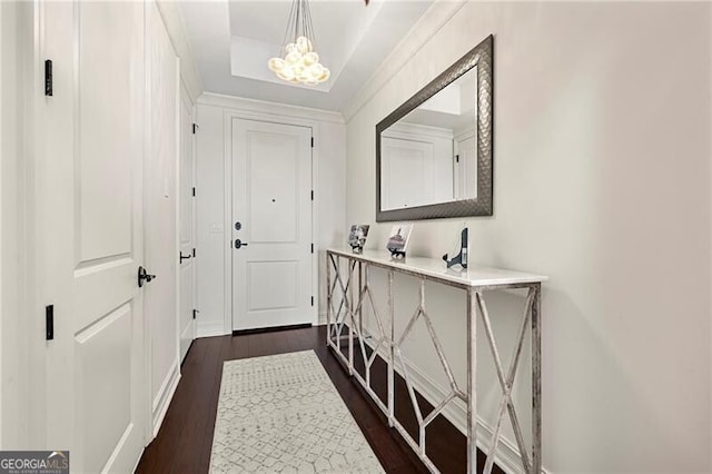 doorway to outside featuring dark wood-style floors, baseboards, and a chandelier