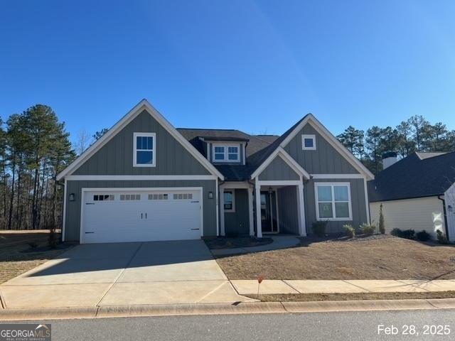 view of front of home with an attached garage, board and batten siding, and driveway