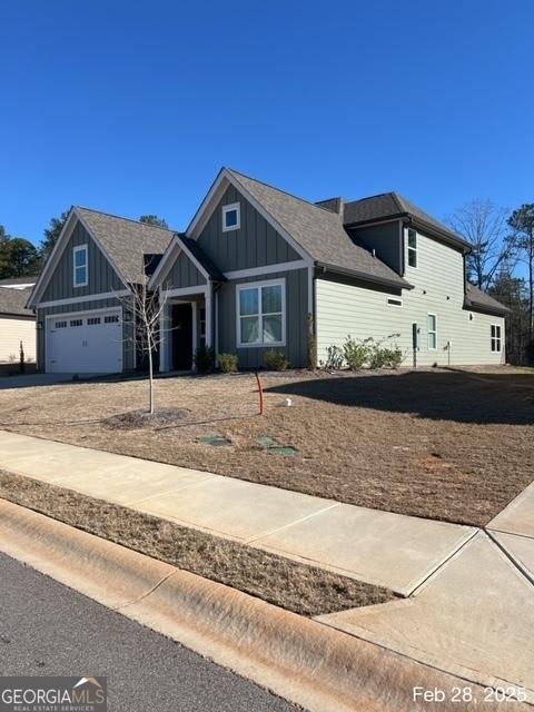 view of front of property featuring concrete driveway, a garage, and board and batten siding