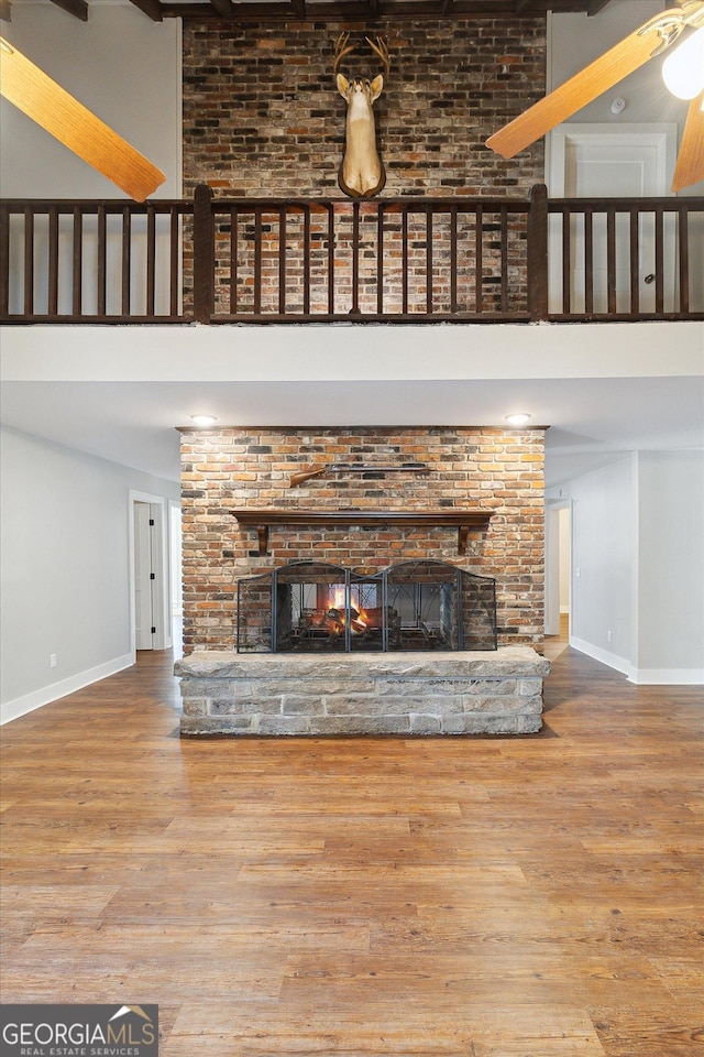 unfurnished living room featuring baseboards, a fireplace, and a towering ceiling