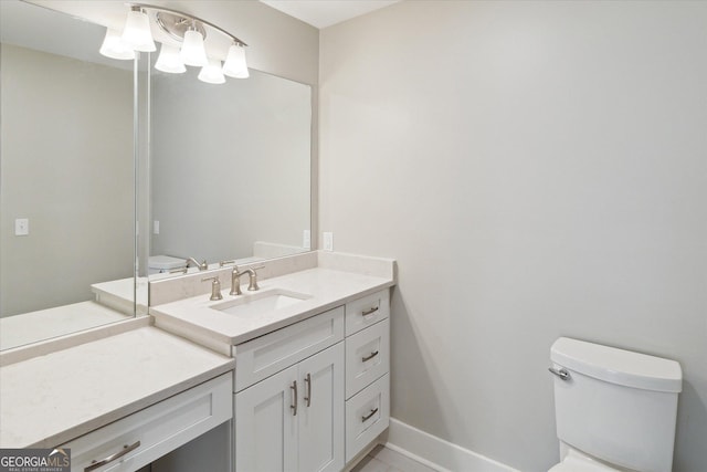 bathroom with vanity, toilet, and baseboards