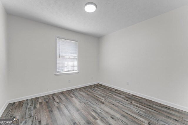 4304 Ruth Ln, Powder Springs, GA 30127 - unfurnished room featuring baseboards, wood finished floors, and a textured ceiling