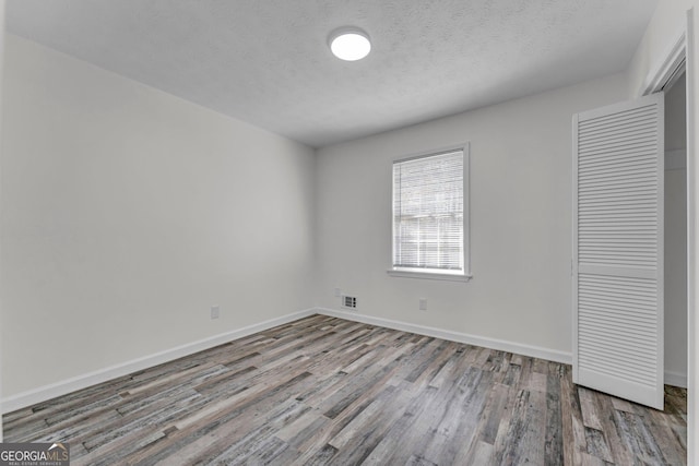 4304 Ruth Ln, Powder Springs, GA 30127 - unfurnished bedroom with baseboards, a closet, wood finished floors, and a textured ceiling