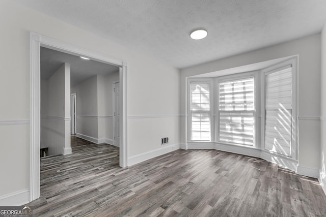 4304 Ruth Ln, Powder Springs, GA 30127 - spare room with visible vents, a textured ceiling, baseboards, and wood finished floors