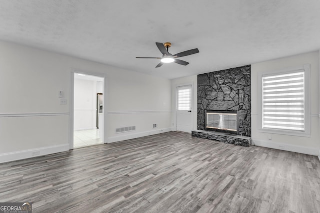 4304 Ruth Ln, Powder Springs, GA 30127 - unfurnished living room with baseboards, a textured ceiling, a ceiling fan, a fireplace, and wood finished floors