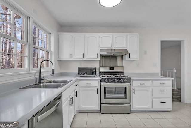 4304 Ruth Ln, Powder Springs, GA 30127 - kitchen with under cabinet range hood, light countertops, a sink, and stainless steel appliances