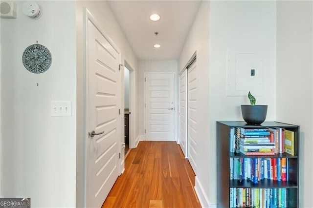 hall featuring recessed lighting, electric panel, and wood finished floors