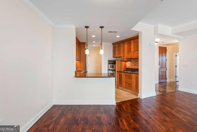 kitchen with dark countertops, visible vents, baseboards, brown cabinetry, and wood-type flooring