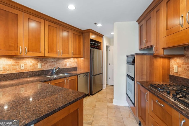 kitchen with a sink, brown cabinetry, and stainless steel appliances