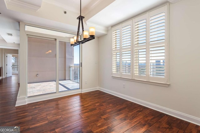 unfurnished room with a healthy amount of sunlight, baseboards, an inviting chandelier, and wood-type flooring