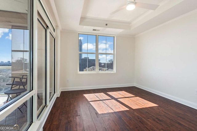 unfurnished room with baseboards, visible vents, ornamental molding, dark wood-type flooring, and a raised ceiling