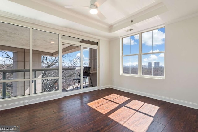 spare room with visible vents, a ceiling fan, hardwood / wood-style flooring, baseboards, and a raised ceiling