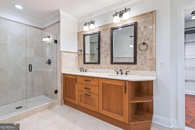 bathroom with a sink, a shower stall, crown molding, and double vanity