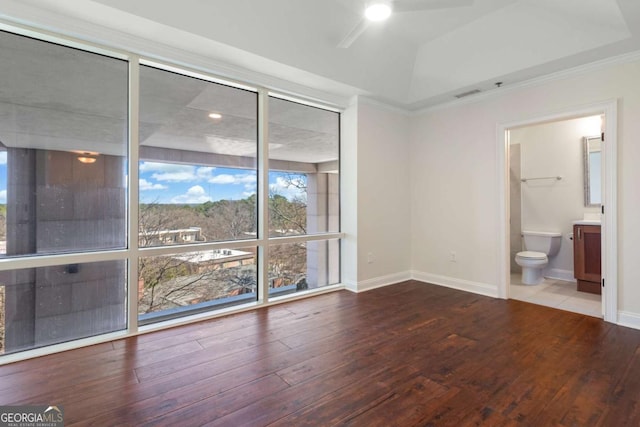 empty room with a ceiling fan, hardwood / wood-style flooring, visible vents, and baseboards