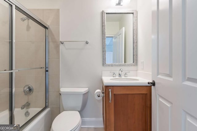 full bathroom with combined bath / shower with glass door, toilet, vanity, and baseboards