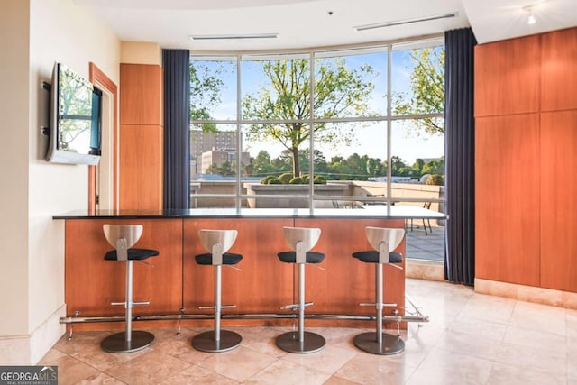 kitchen with a wealth of natural light, dark countertops, and a kitchen bar