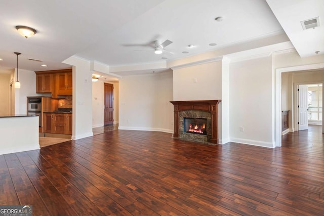 unfurnished living room with baseboards, visible vents, wood-type flooring, and ceiling fan